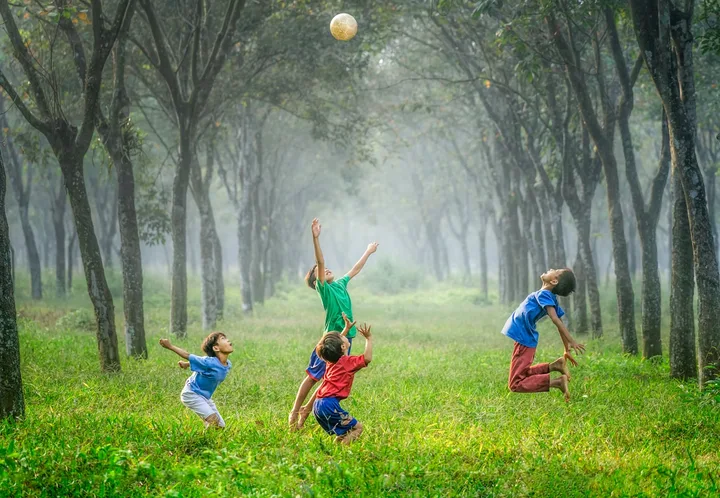 Niños jugando con una pelota sobre el césped