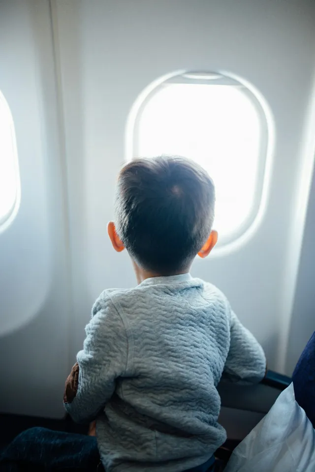 Niño asomado a la ventanilla de un avión