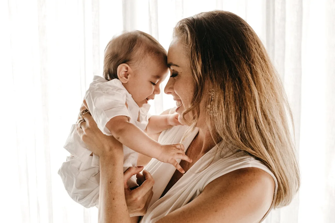 Madre sonriendo con su bebé en brazos