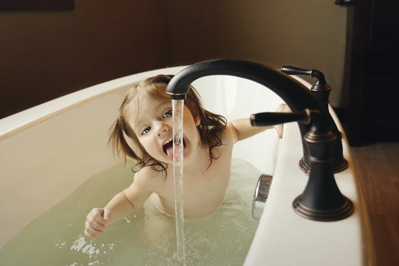 Bebé recién nacido en bañera, primer baño